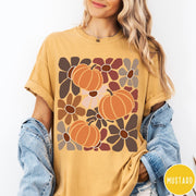 Comfort Colors tee in Mustard featuring boho floral style graphic with three orange pumpkins and brown flowers