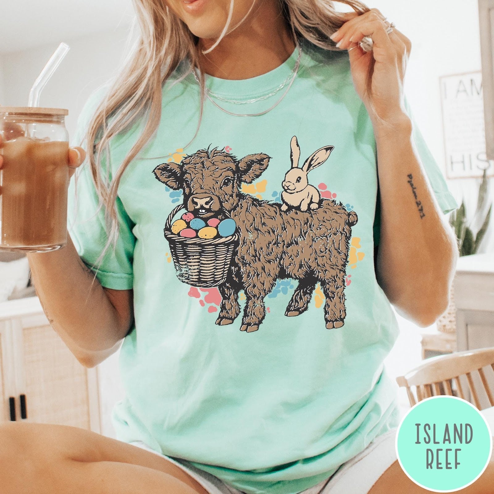 Comfort Colors tee in Island Reef featuring graphic style Highland cow and bunny with an Easter egg basket
