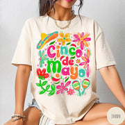 Comfort Colors tee in Ivory featuring festive Cinco de Mayo graphic with sombrero, maracas, and colorful flowers