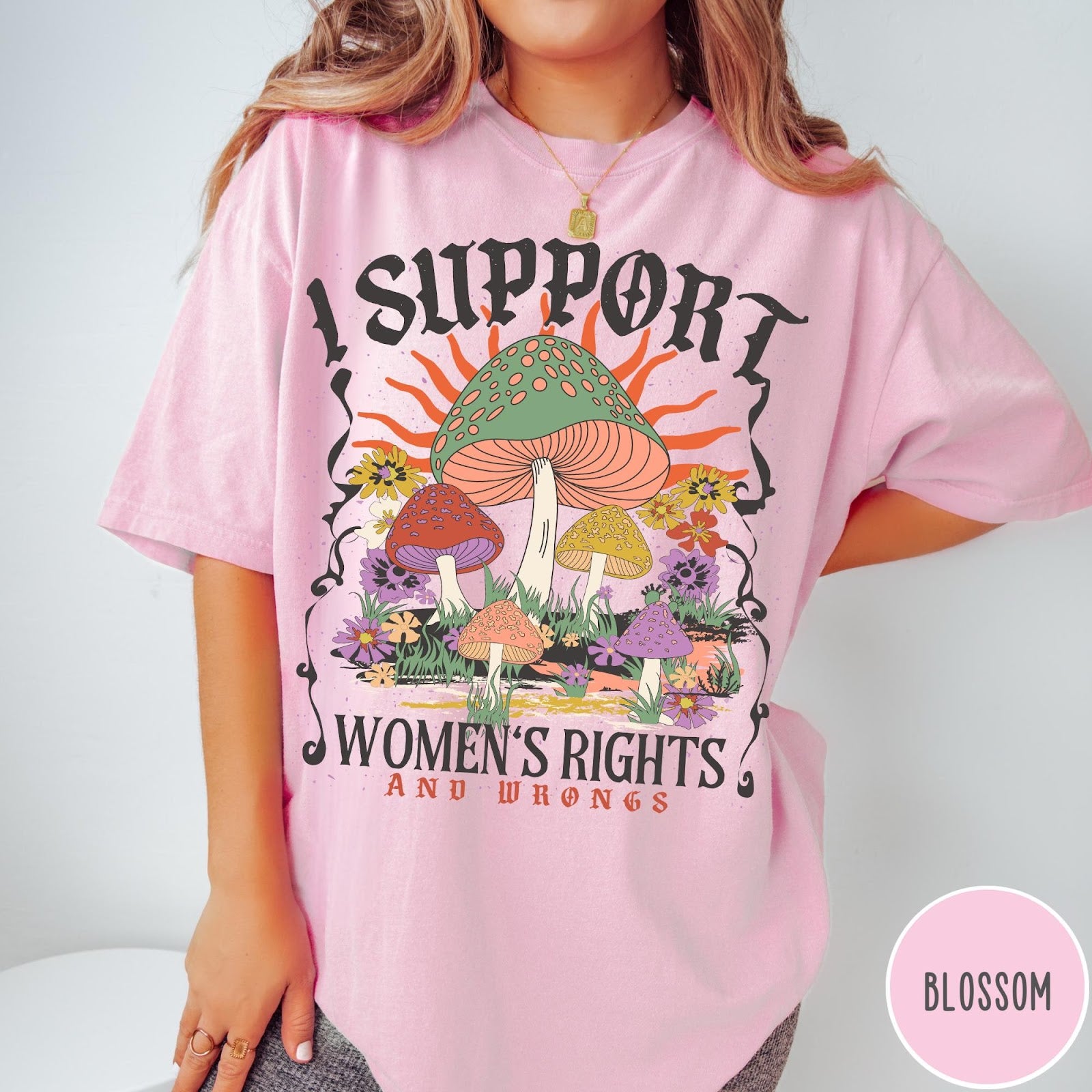 Comfort Colors tee in Blossom featuring retro graphic design with colorful mushrooms, flowers, and sun illustration