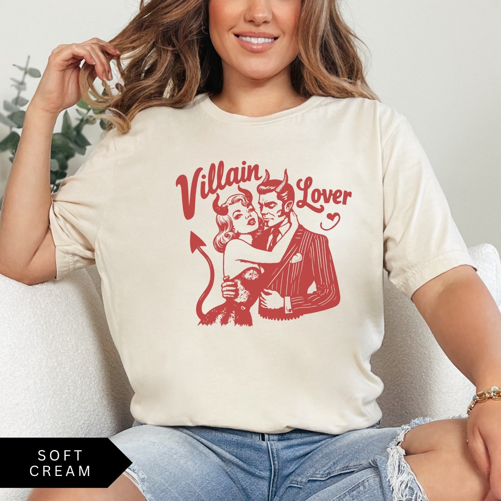 Comfort Colors tee in Soft Cream featuring vintage style graphic of a devilish couple embracing with text Villain Lover