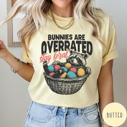 Comfort Colors tee in Butter featuring graphic illustration of a raccoon sitting in an Easter basket