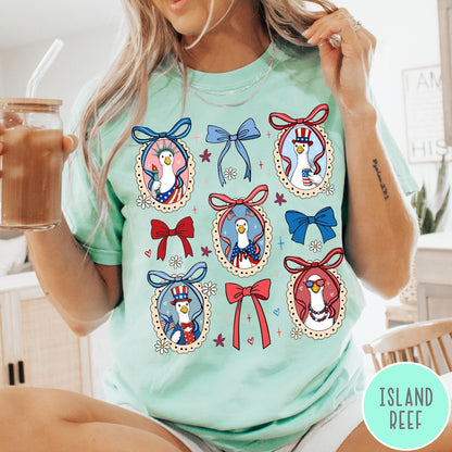 Comfort Colors tee in Island Reef featuring coquette style patriotic goose graphic with bows and floral accents