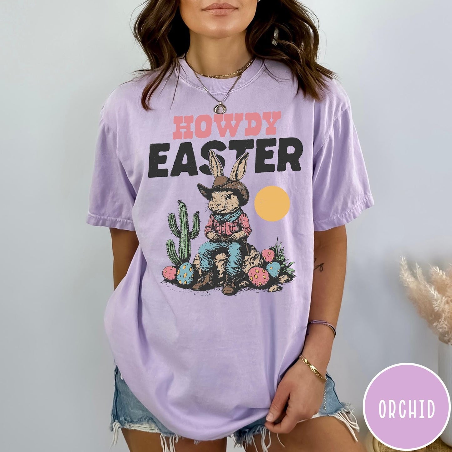 Comfort Colors tee in Orchid featuring western design style cowboy bunny sitting on a rock with cactus