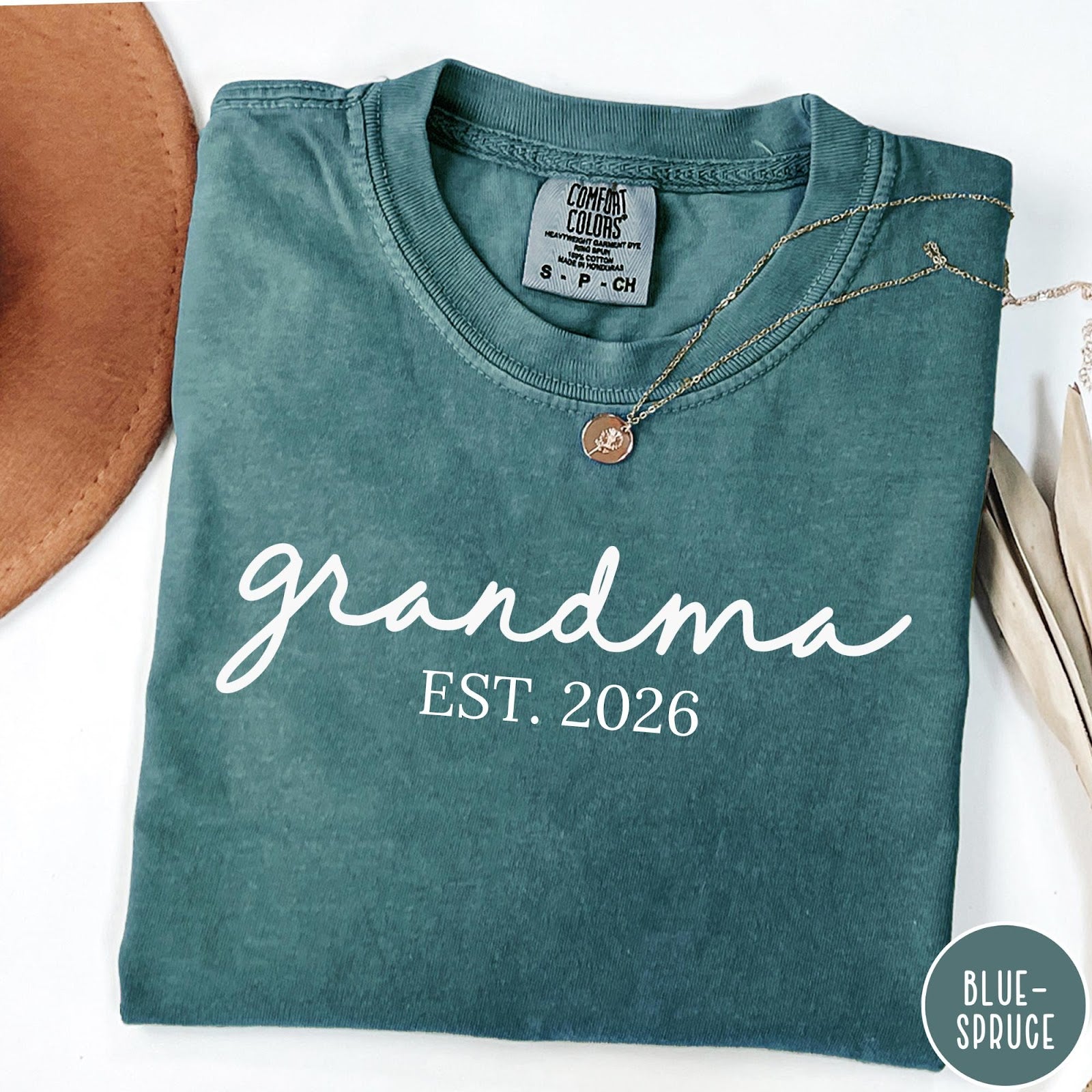 Comfort Colors tee in Blue Spruce featuring script design Grandma Est. 2026 announcement graphic in white