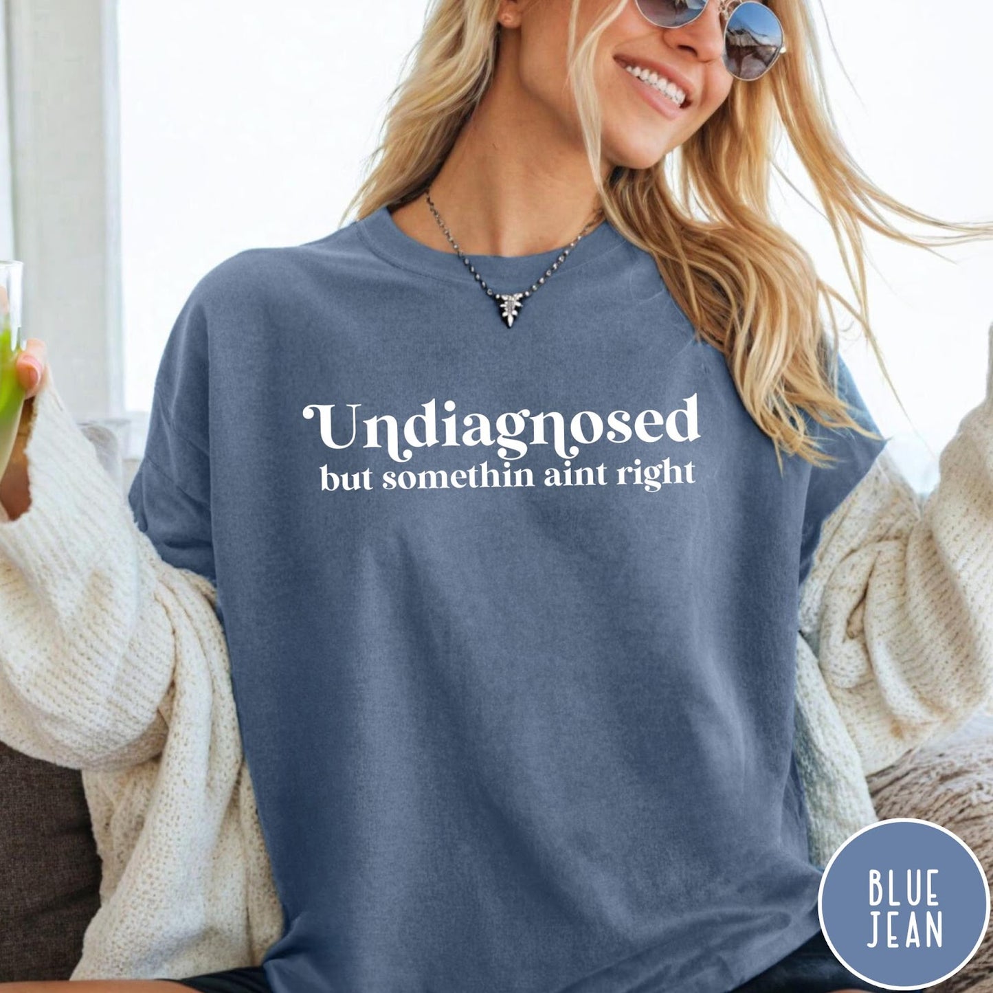Comfort Colors tee in Blue Jean featuring mental health humor text that reads Undiagnosed but somethin aint right