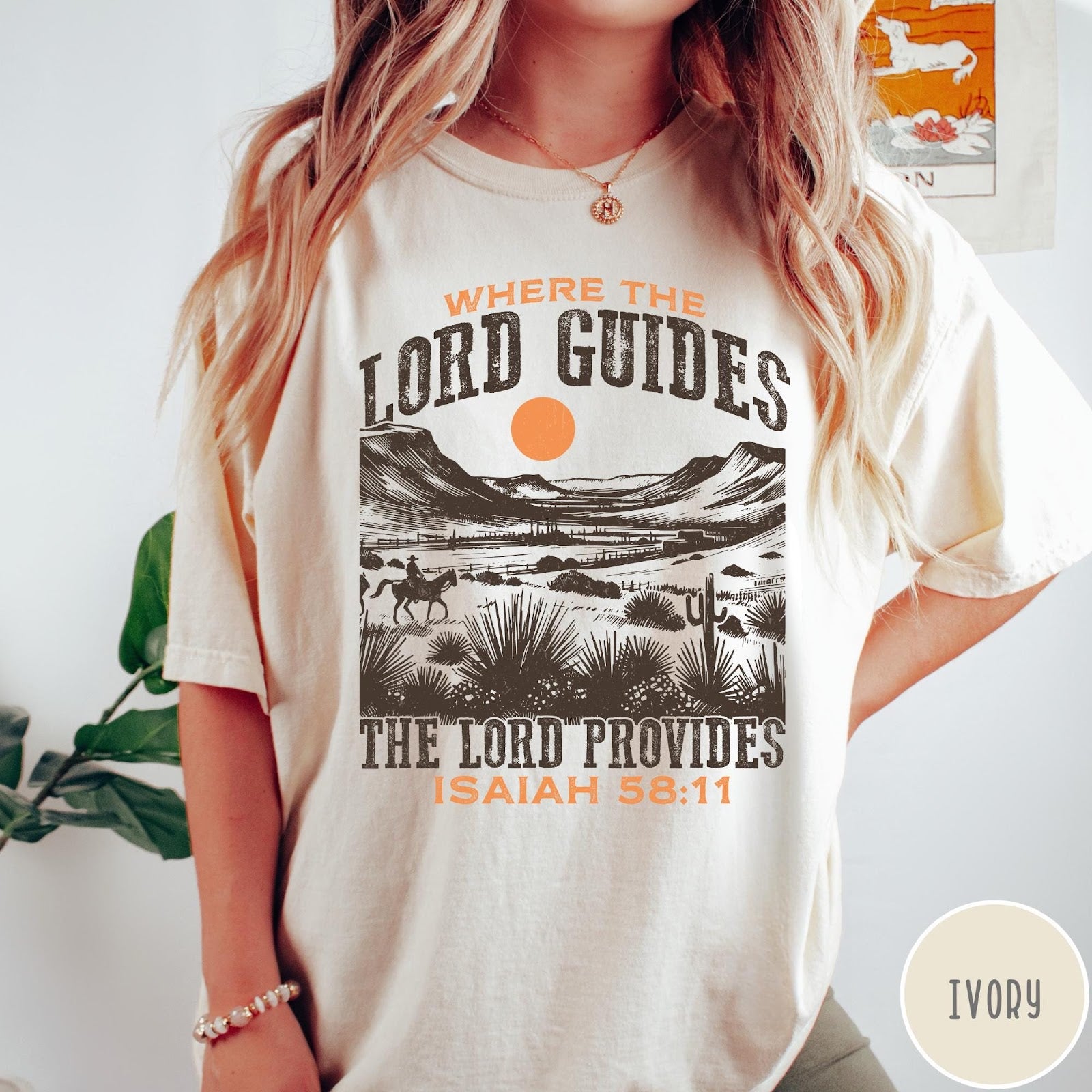 Comfort Colors tee in Ivory featuring desert landscape graphic with a rider and sun design.