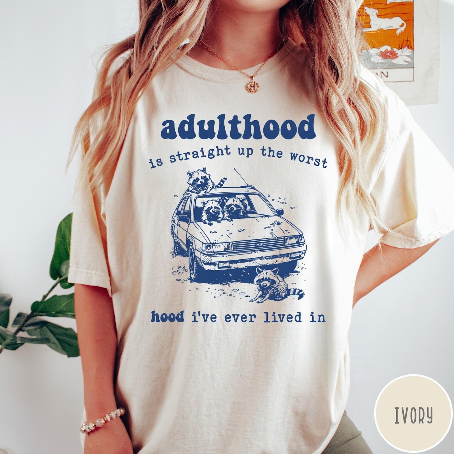 Comfort Colors tee in Ivory featuring illustrated style graphic of raccoons sitting in and around a car