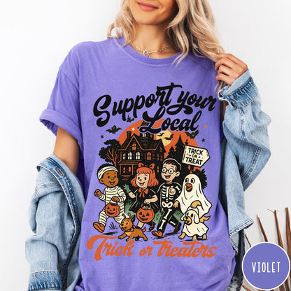 Comfort Colors tee in Violet featuring vintage style trick or treaters graphic with a haunted house background