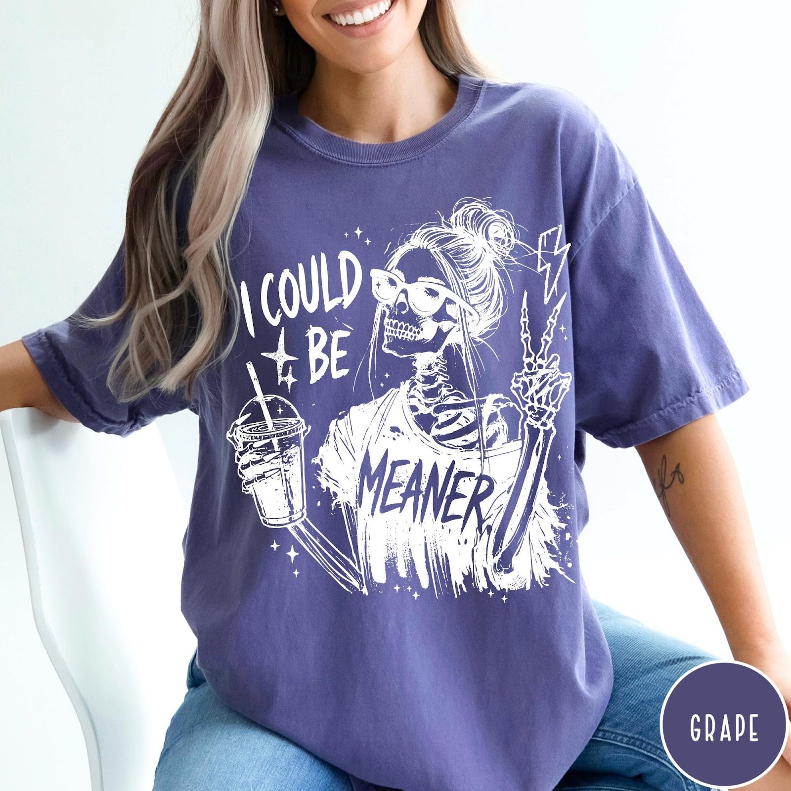 Comfort Colors tee in Grape featuring skeleton graphic with sunglasses holding a drink and making peace sign