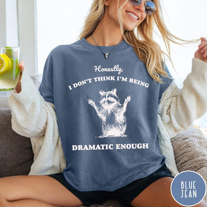 Comfort Colors tee in Blue Jean featuring vintage style graphic of a raccoon with arms raised and text