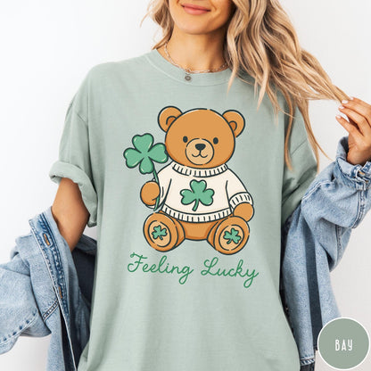 Comfort Colors tee in Bay featuring cute teddy bear graphic wearing a sweater with shamrocks