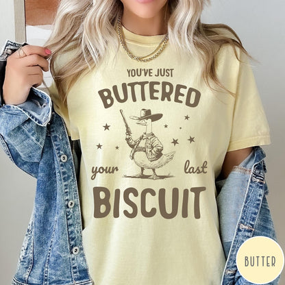 Comfort Colors tee in Butter featuring western graphic style cowboy goose holding a revolver with star accents
