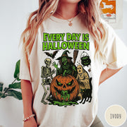 Comfort Colors tee in Ivory featuring Halloween graphic with a witch, skeleton, ghost, and a dripping pumpkin.