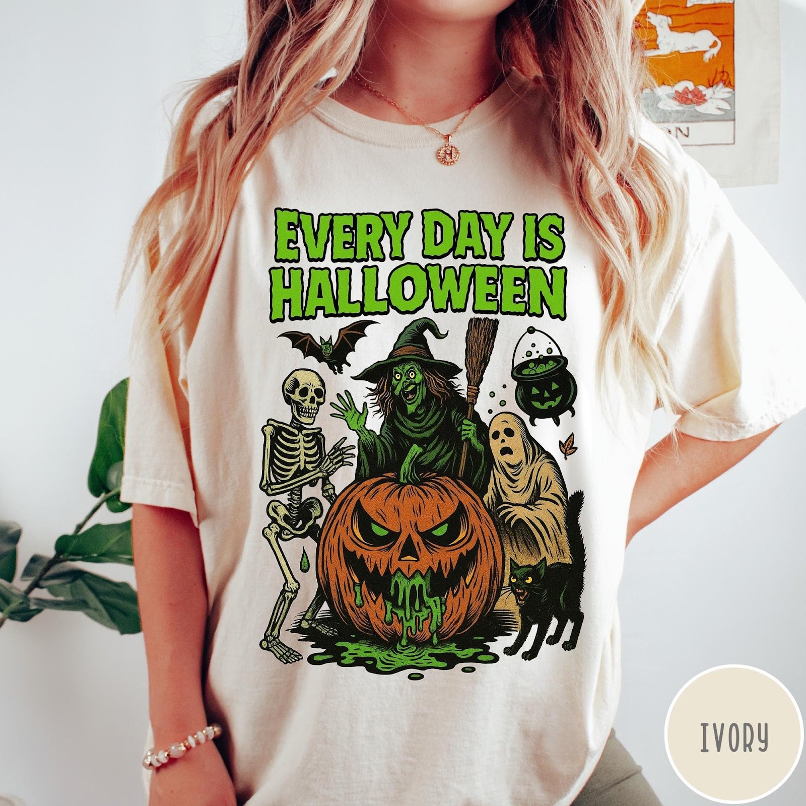 Comfort Colors tee in Ivory featuring Halloween graphic with a witch, skeleton, ghost, and a dripping pumpkin.