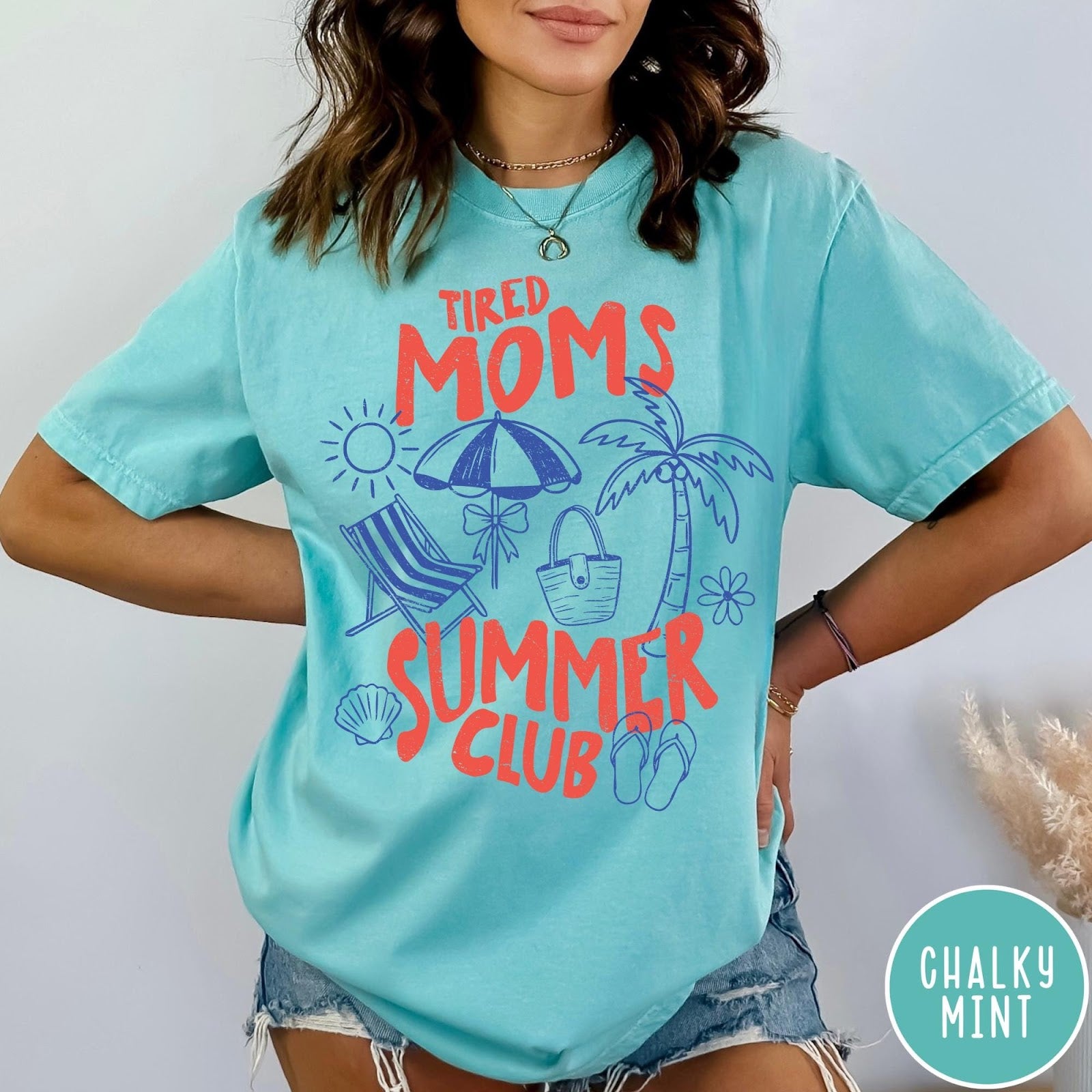 Comfort Colors tee in Chalky Mint featuring beach vacation style graphic with sun, umbrella, palm tree, and bag