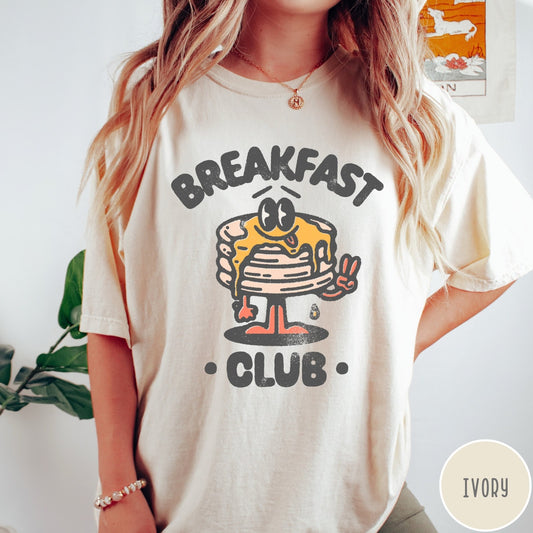 Comfort Colors tee in Ivory featuring retro style graphic of a pancake character with syrup and peace sign