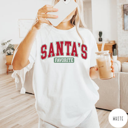 Comfort Colors tee in White featuring collegiate style Santa's Favorite Christmas graphic with red and green text