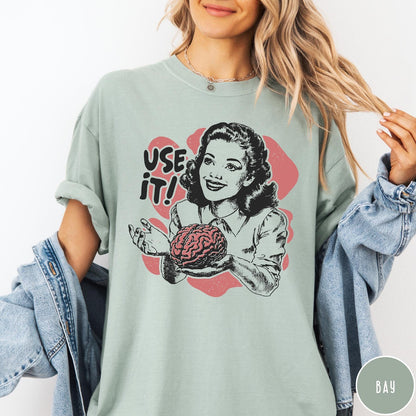 Comfort Colors tee in Bay featuring retro design of a woman holding a brain with text Use It