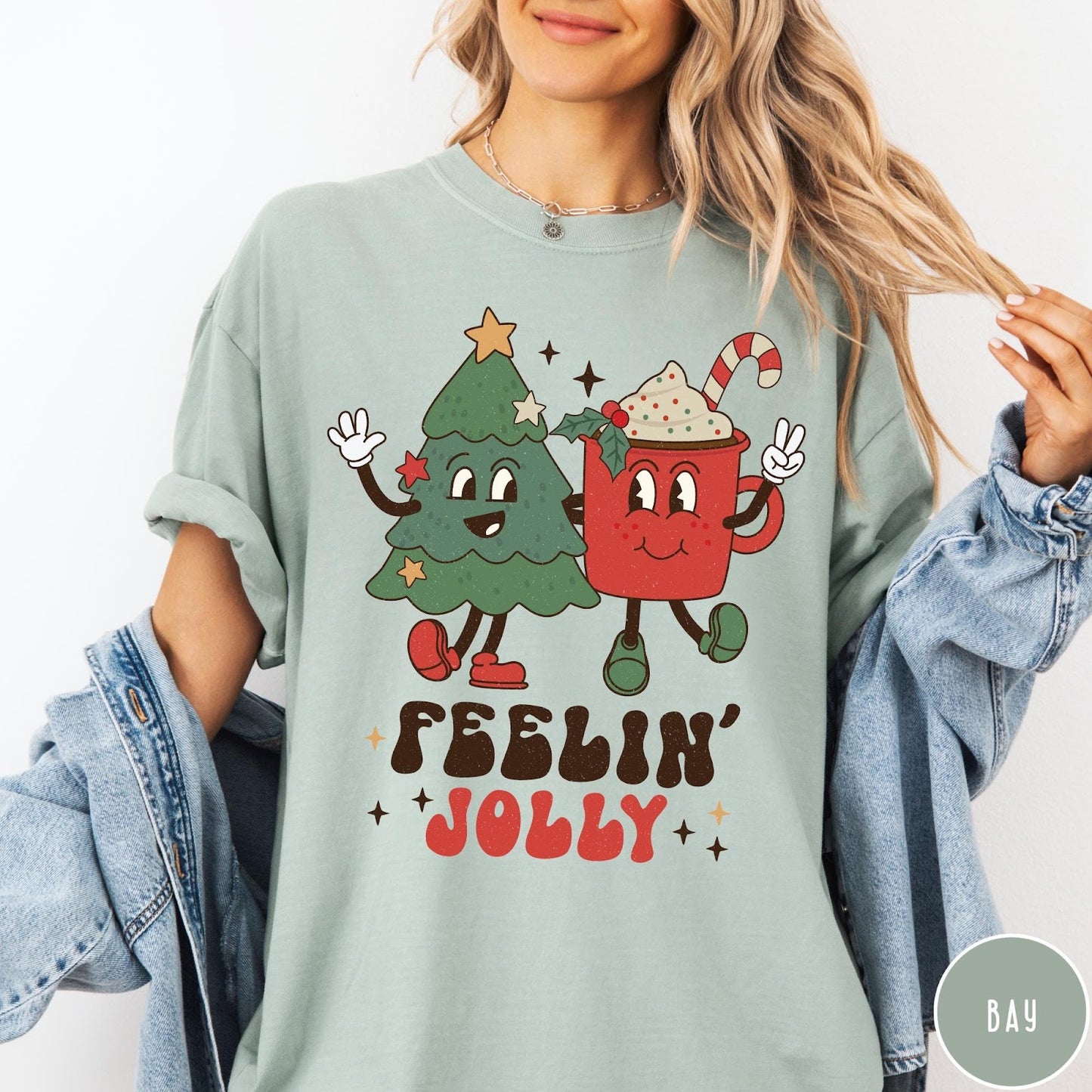 Comfort Colors tee in Bay featuring retro style graphic of a cartoon Christmas tree and cocoa mug