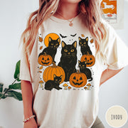 Comfort Colors tee in Ivory featuring Halloween style graphic with black cats, pumpkins, bats, and fall leaves