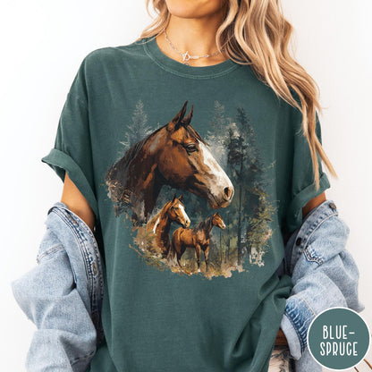 Comfort Colors tee in Blue Spruce featuring vintage style graphic of three horses standing in a pine forest