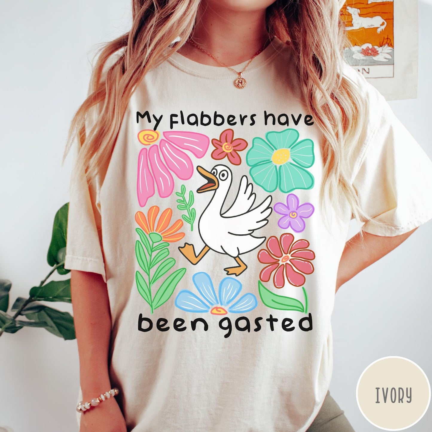 Comfort Colors tee in Ivory featuring playful cartoon style graphic of a goose surrounded by colorful flowers