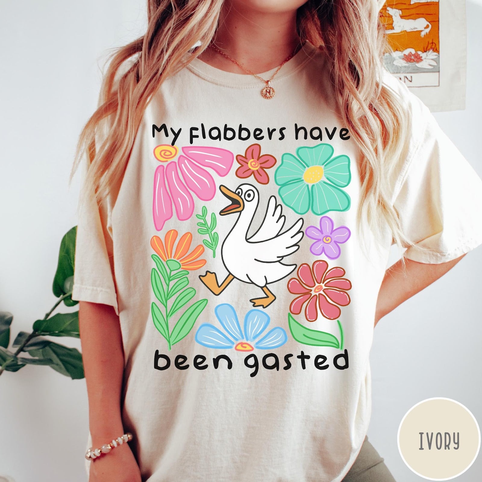 Comfort Colors tee in Ivory featuring playful cartoon style graphic of a goose surrounded by colorful flowers