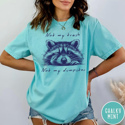 Comfort Colors tee in Chalky Mint featuring illustrated style graphic of a winking raccoon with text not my trash