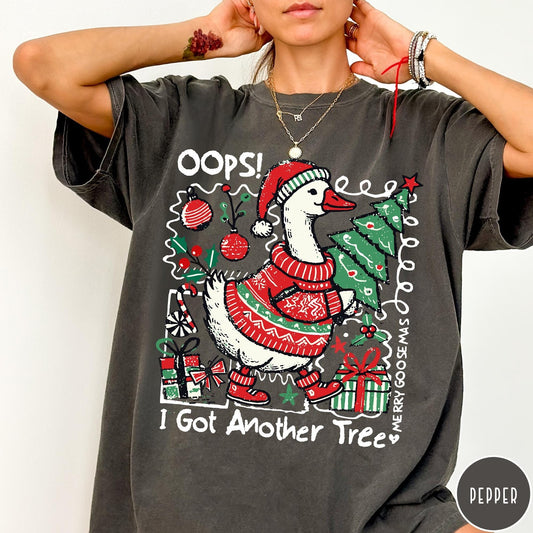 Comfort Colors tee in Pepper featuring festive goose graphic wearing a Santa hat and Christmas sweater holding tree
