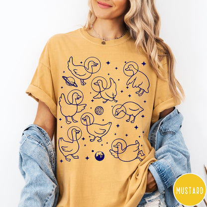 Comfort Colors tee in Mustard featuring line art graphic of multiple geese wearing astronaut helmets in space