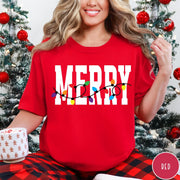 Comfort Colors tee in Red featuring holiday style graphic with white Merry text and colorful Christmas lights