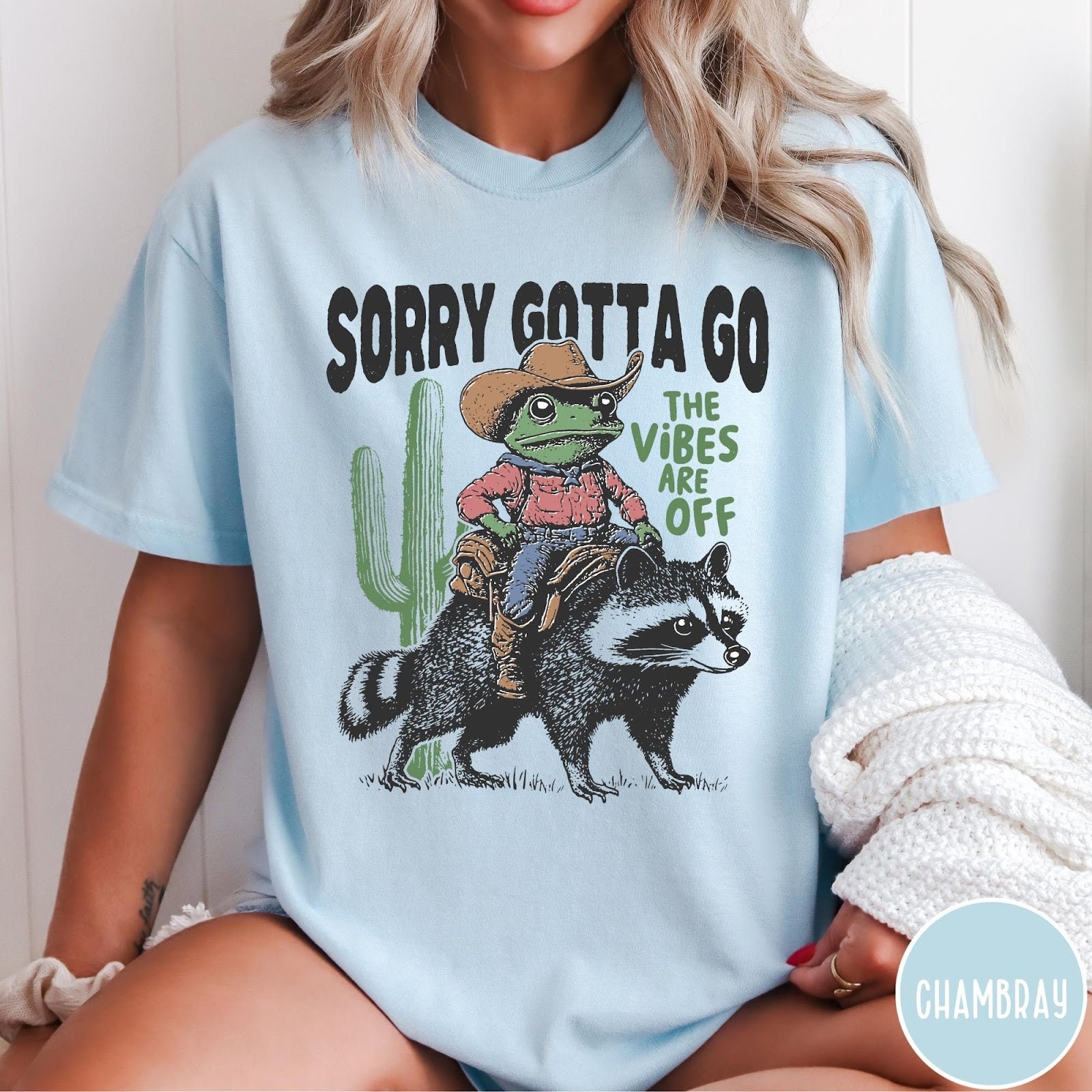 Comfort Colors tee in Chambray featuring western graphic of a cowboy frog riding a raccoon with cactus