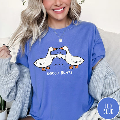 Comfort Colors tee in Flo Blue featuring cartoon style graphic of two geese giving each other a fist bump