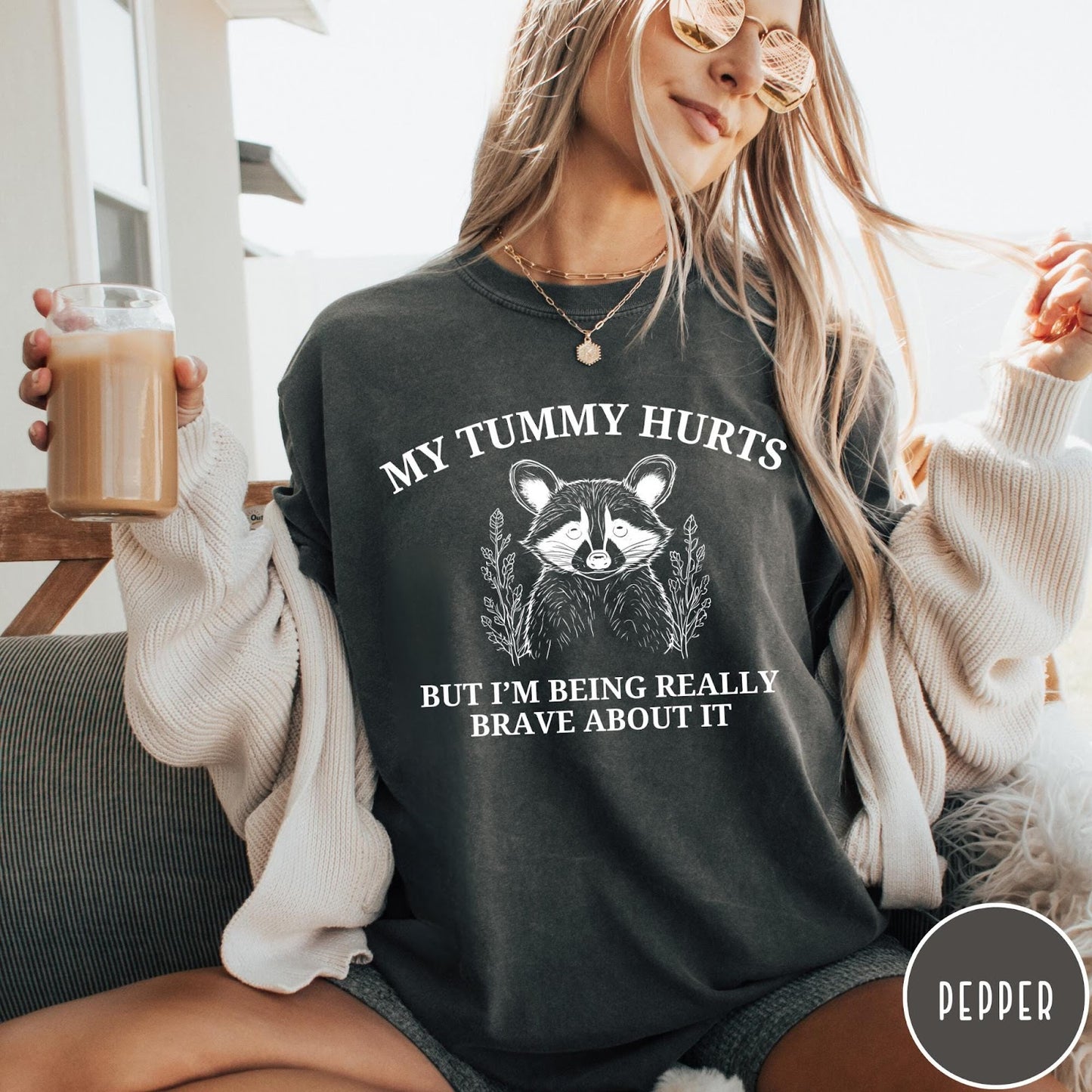 Comfort Colors tee in Pepper featuring line art style raccoon graphic with My Tummy Hurts text design