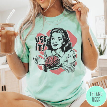 Comfort Colors tee in Island Reef featuring retro style graphic of a woman holding a human brain