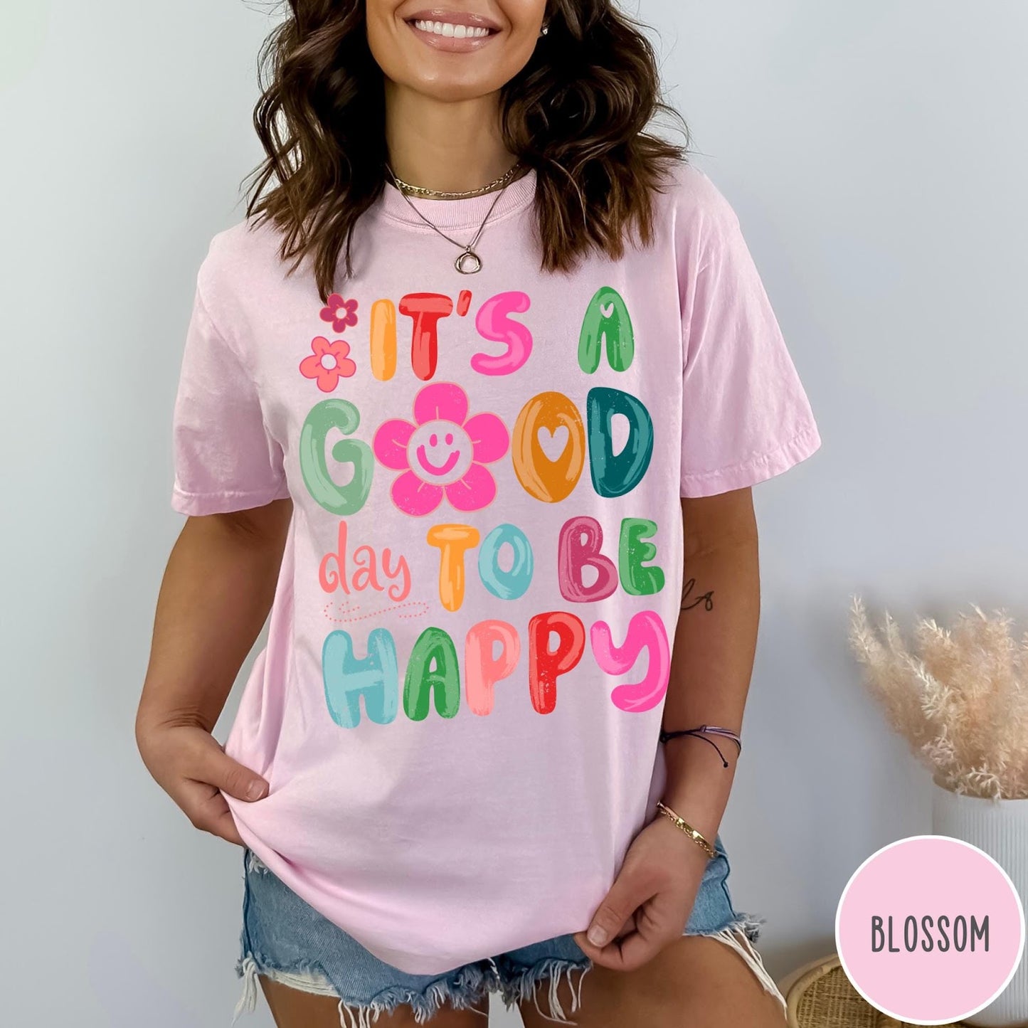 Comfort Colors tee in Blossom featuring typography and floral elements with a smiley face graphic design