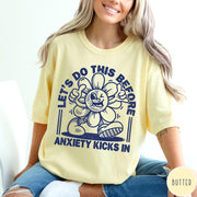 Comfort Colors tee in Butter featuring retro graphic style winking flower character with anxiety text design