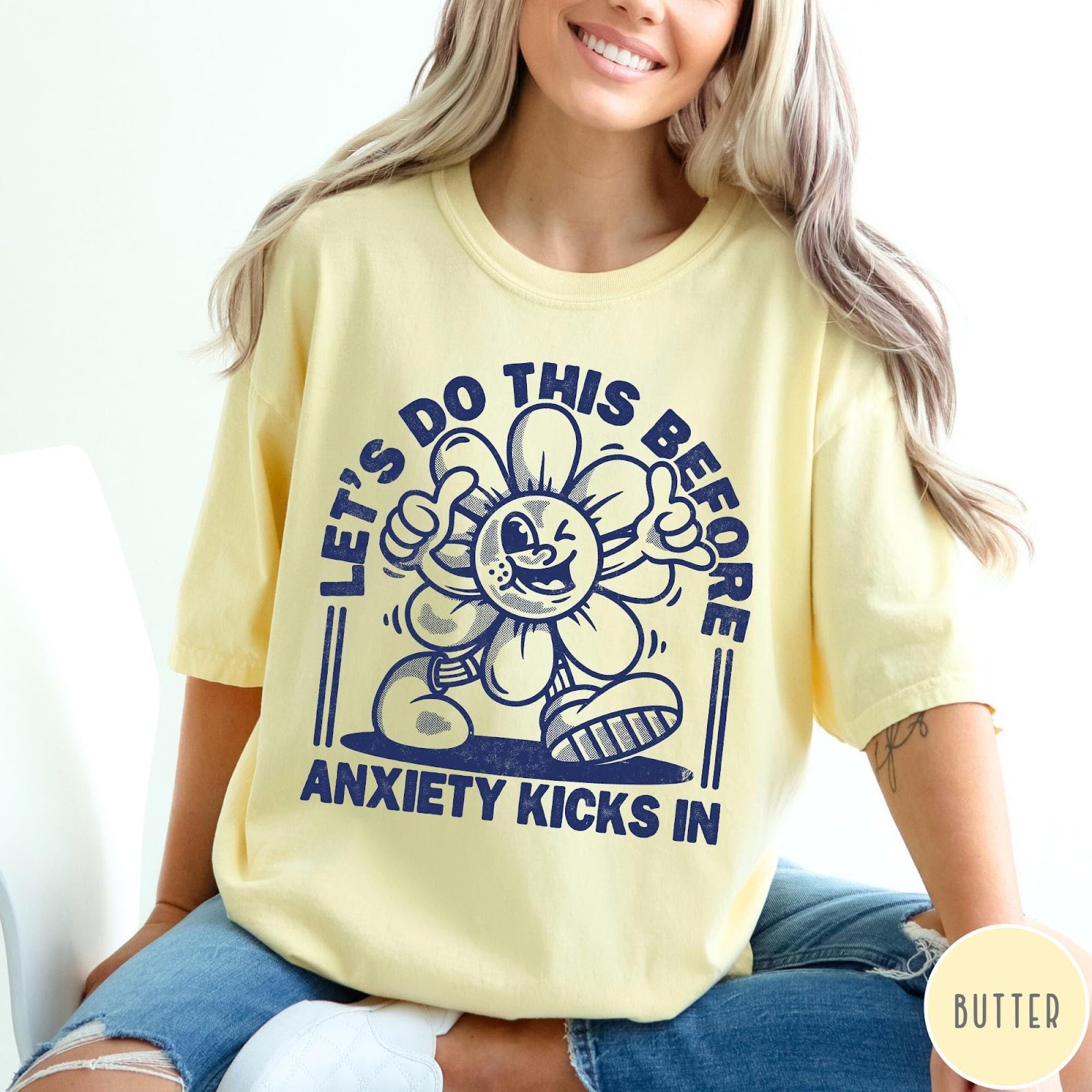 Comfort Colors tee in Butter featuring retro graphic style winking flower character with anxiety text design