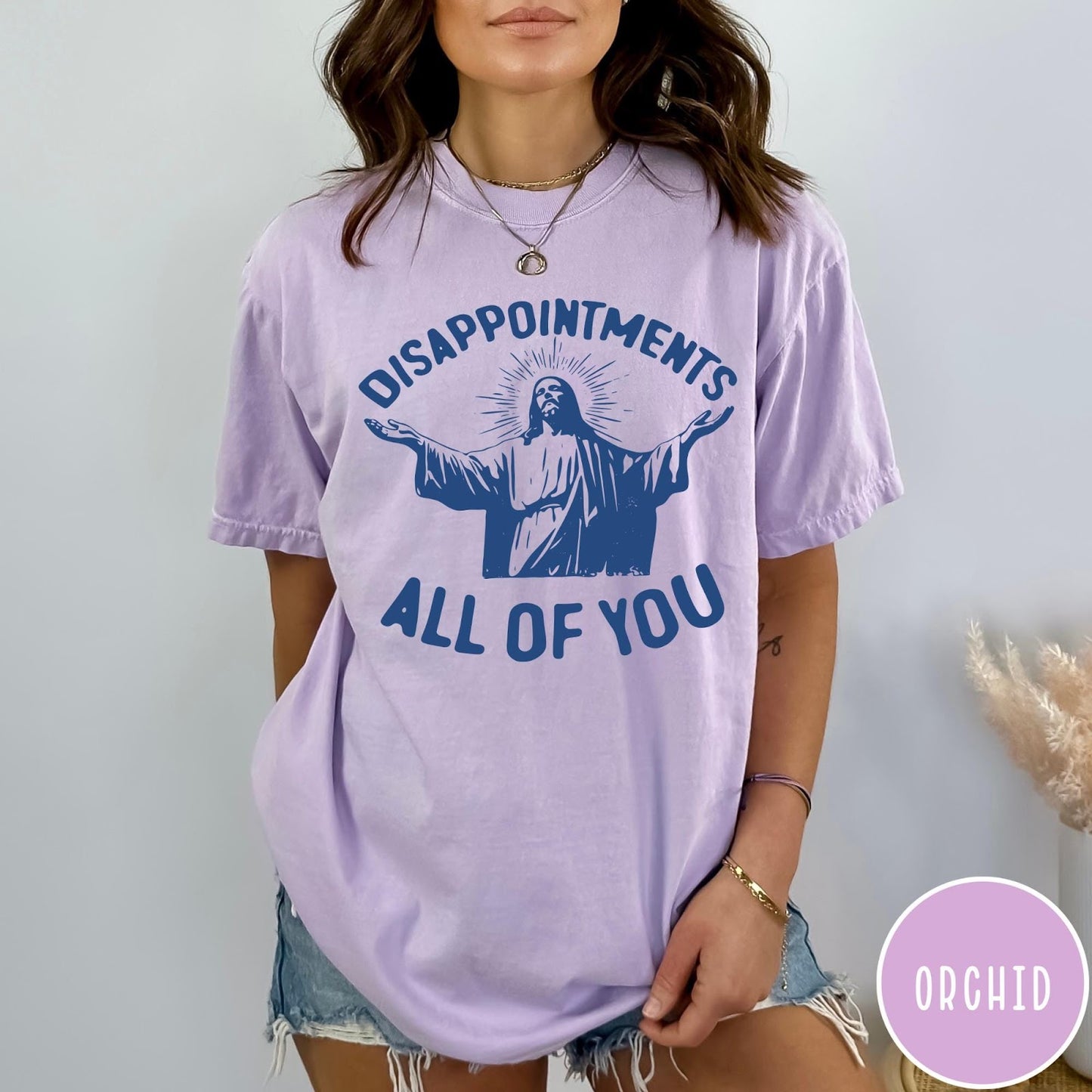 Comfort Colors tee in Orchid featuring screen print graphic of Jesus with arms outstretched and text Disappointments All Of You