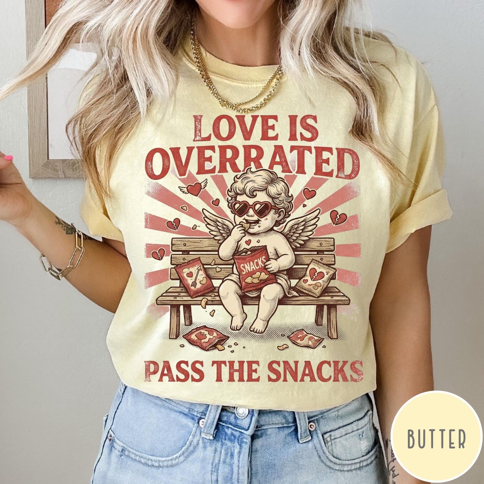 Comfort Colors tee in Butter featuring vintage style graphic of a cherub eating snacks on a bench