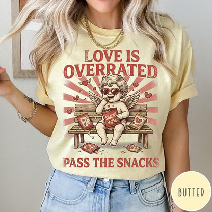 Comfort Colors tee in Butter featuring vintage style graphic of a cherub eating snacks on a bench
