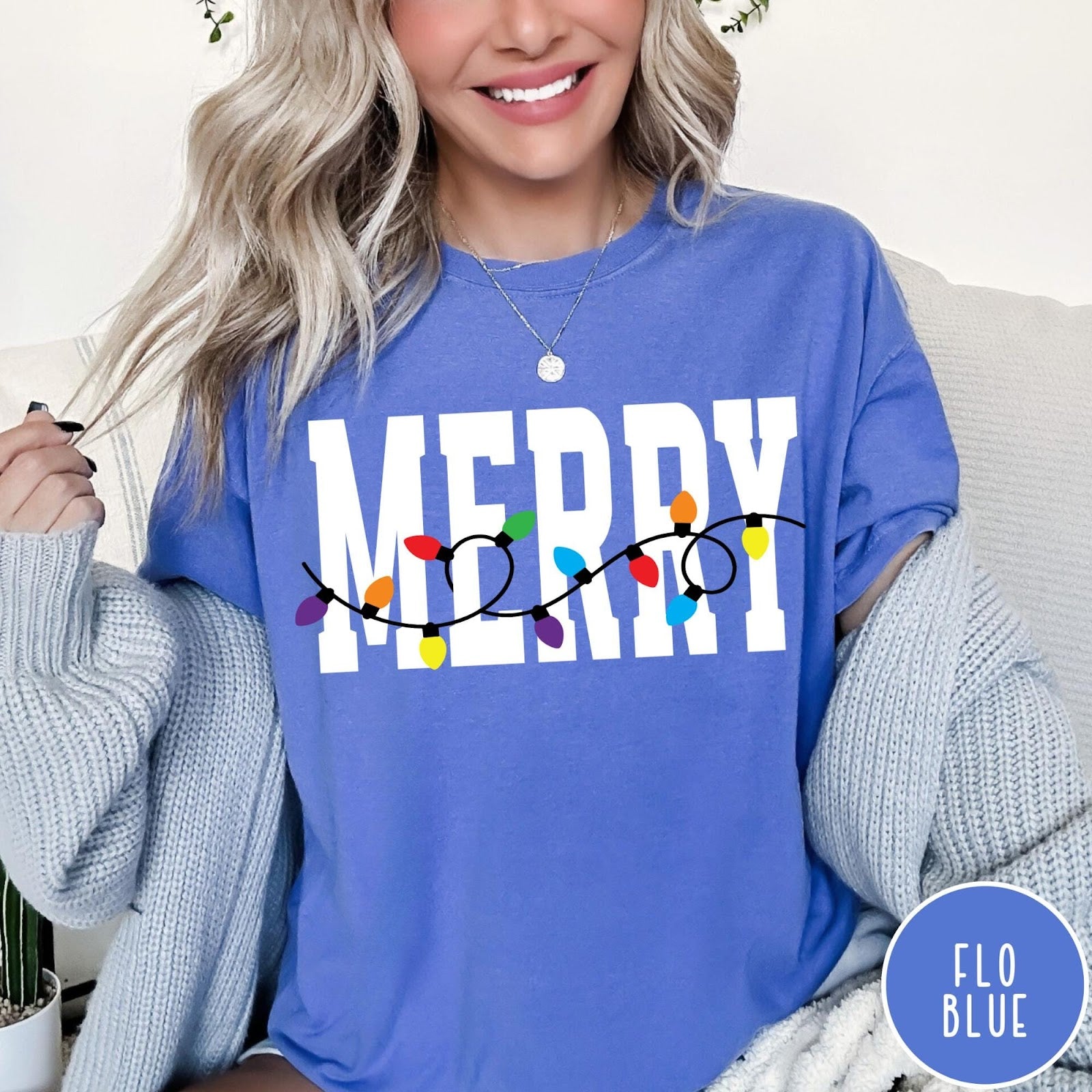 Comfort Colors tee in Flo Blue featuring festive holiday style graphic with Merry text and Christmas lights