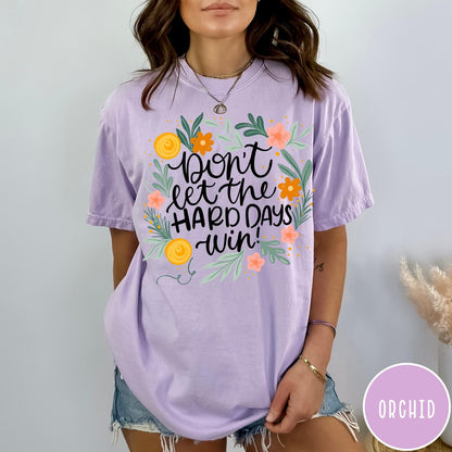 Comfort Colors tee in Orchid featuring floral design with mental health encouragement text Don't Let The Hard Days Win