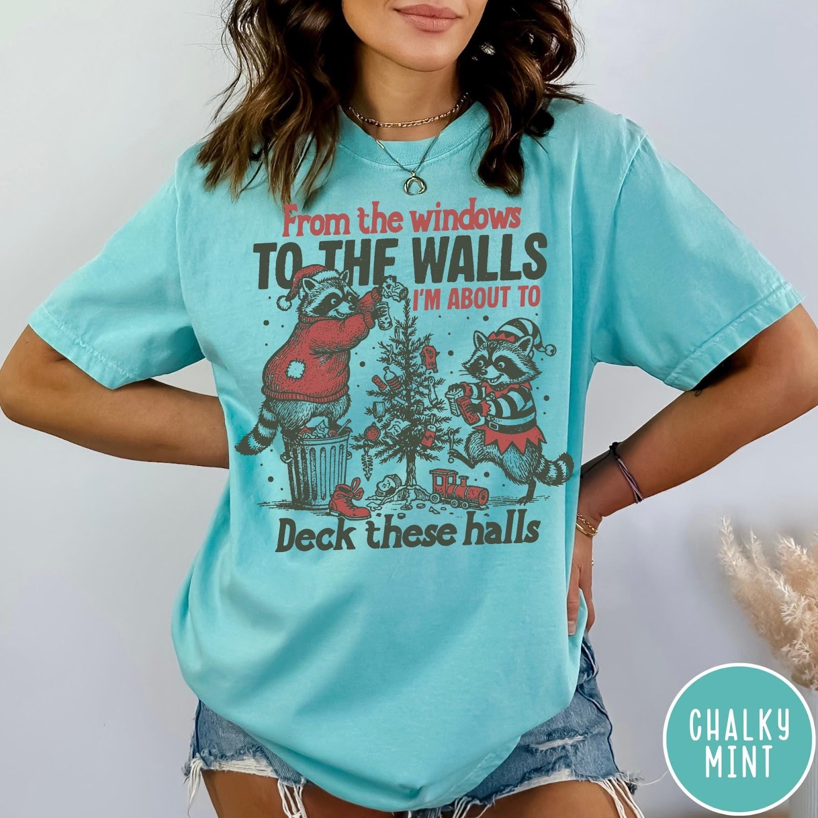 Comfort Colors tee in Chalky Mint featuring vintage style graphic of two raccoons decorating a Christmas tree