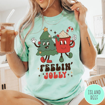 Comfort Colors tee in Island Reef featuring retro style graphic of a cartoon Christmas tree and cocoa mug