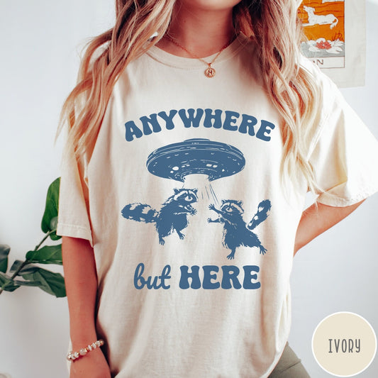 Comfort Colors tee in Ivory featuring whimsical graphic style with two raccoons being abducted by a UFO