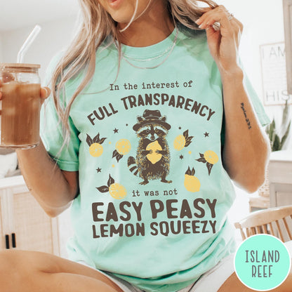 Comfort Colors tee in Island Reef featuring graphic illustration of a raccoon wearing a hat holding a lemon