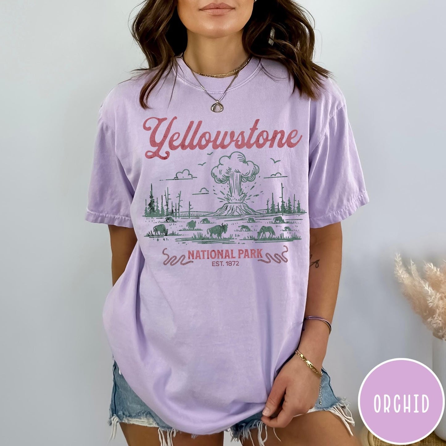 Comfort Colors tee in Orchid featuring retro graphic design of Yellowstone National Park with bison and geyser