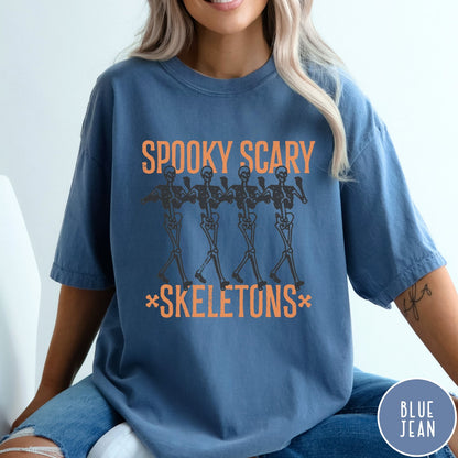 Comfort Colors tee in Blue Jean featuring dancing skeletons graphic with Spooky Scary Skeletons text in orange